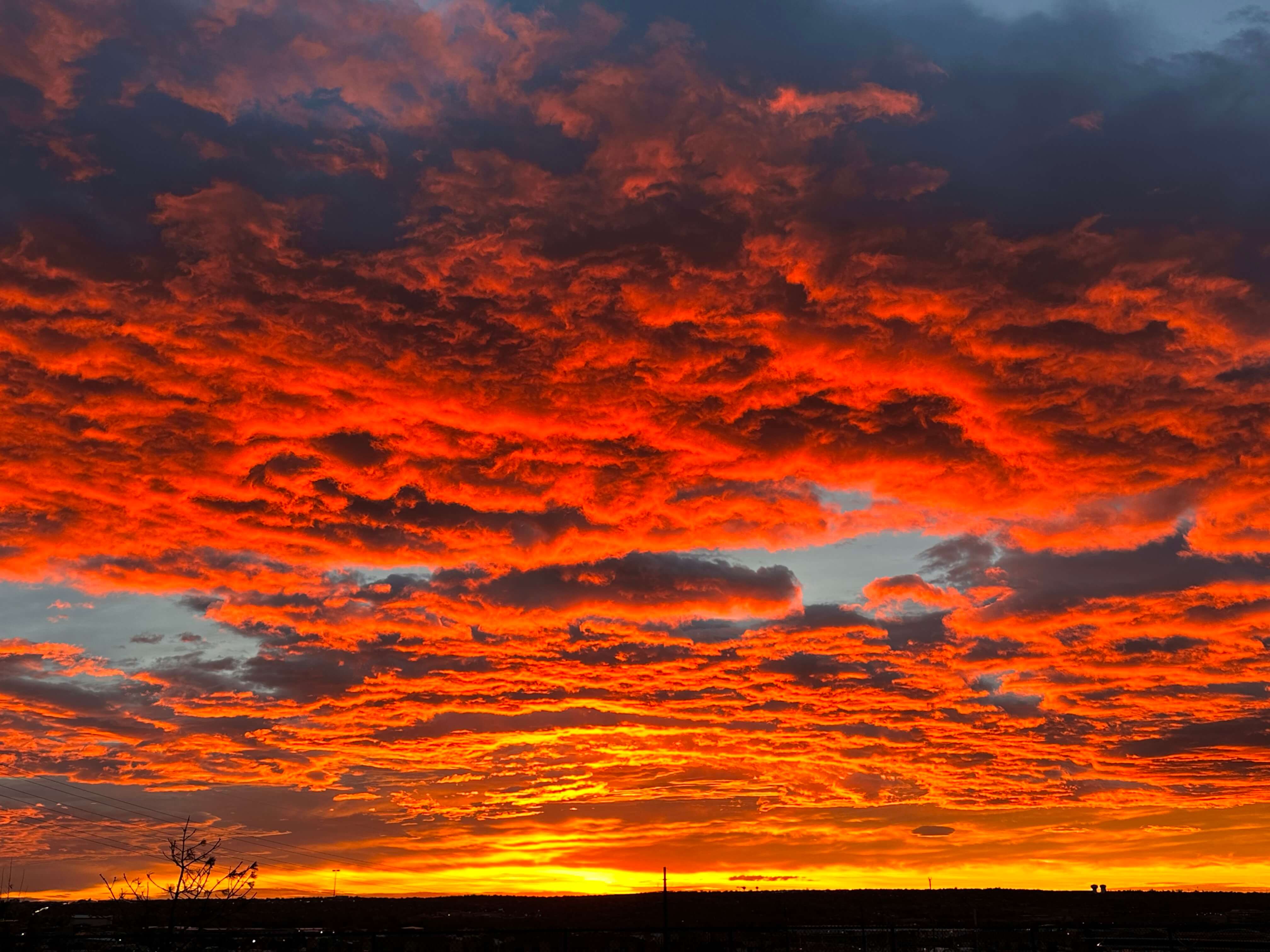 Bright orange sunset with many clouds and horizon