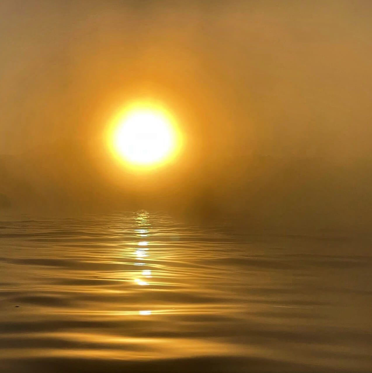Hazy image of the sun above water
